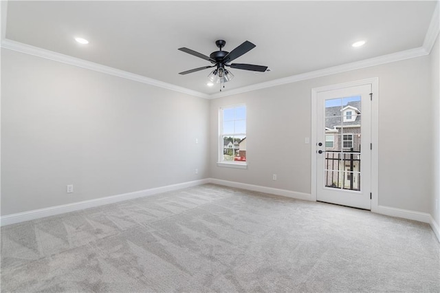 carpeted spare room with ceiling fan and ornamental molding