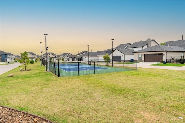 view of tennis court featuring a lawn