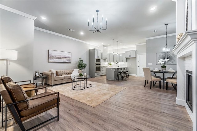 living room featuring sink, crown molding, and wood-type flooring