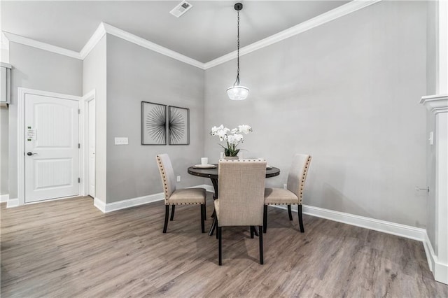 dining room featuring hardwood / wood-style floors and crown molding