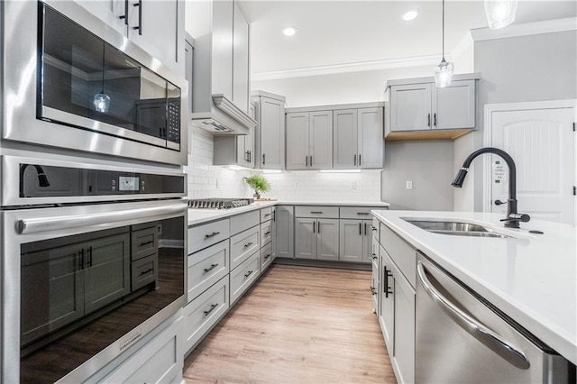 kitchen with sink, stainless steel appliances, ornamental molding, and backsplash