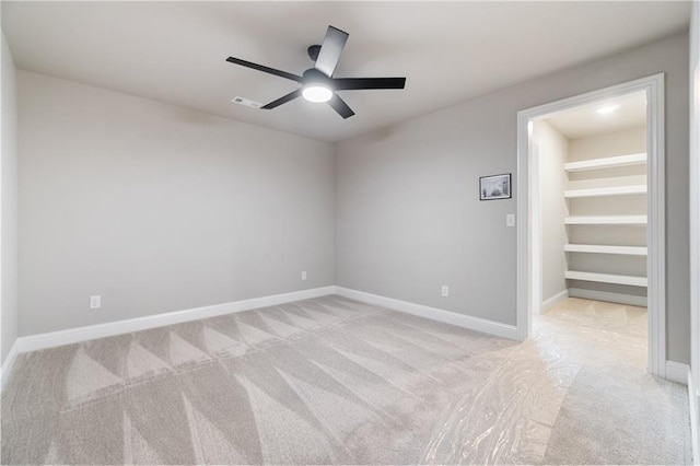 empty room featuring ceiling fan and light carpet