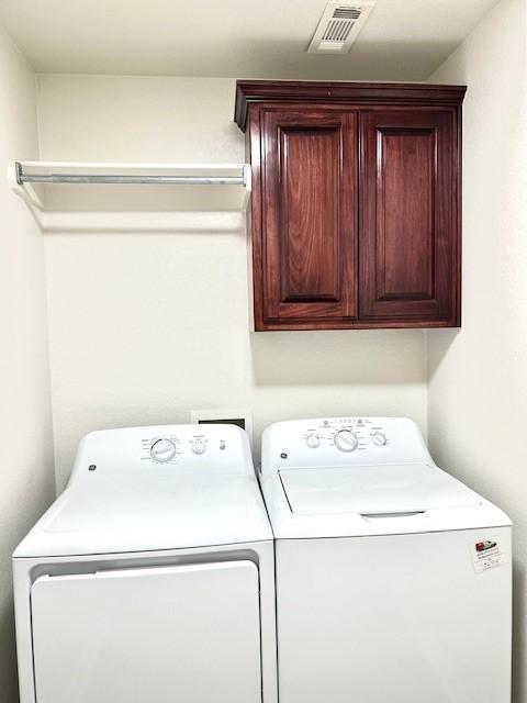 laundry area featuring washing machine and dryer and cabinets