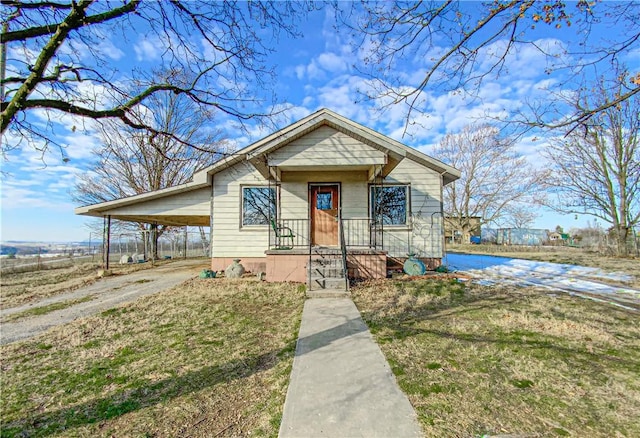 bungalow featuring a carport and a front lawn