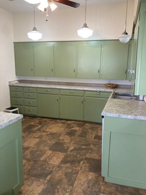 kitchen with decorative light fixtures, sink, ceiling fan, and green cabinets