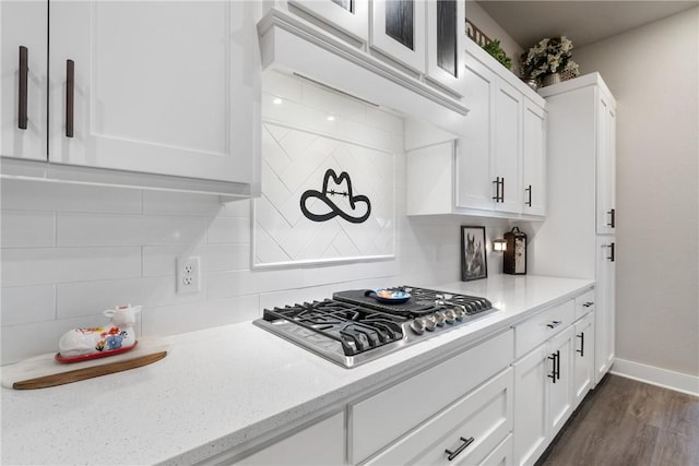 kitchen featuring light stone countertops, stainless steel gas cooktop, white cabinetry, and decorative backsplash