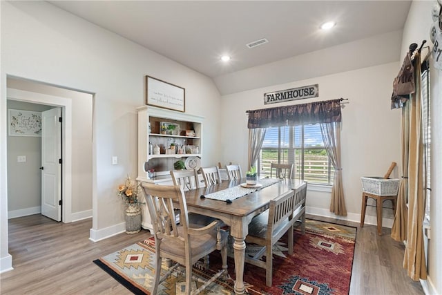 dining room with lofted ceiling and light wood-type flooring