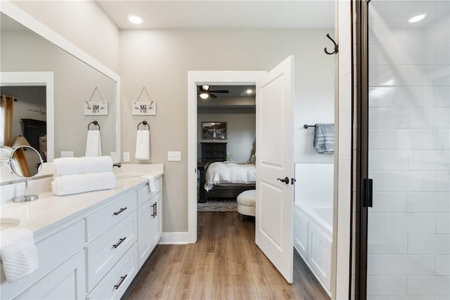 bathroom featuring ceiling fan, separate shower and tub, vanity, and hardwood / wood-style flooring