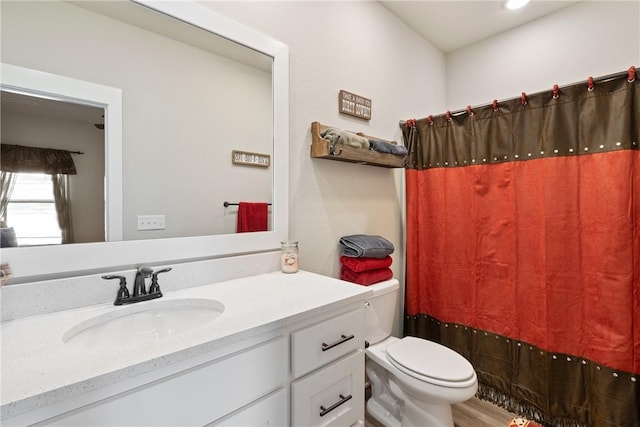 bathroom with toilet, vanity, and hardwood / wood-style flooring