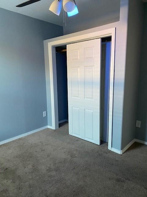 unfurnished bedroom featuring carpet flooring, baseboards, and a ceiling fan