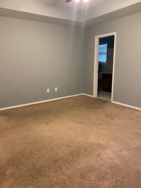 carpeted empty room with baseboards and ceiling fan