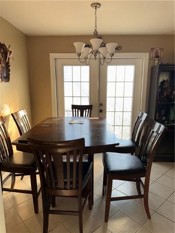 tiled dining area with an inviting chandelier and a healthy amount of sunlight