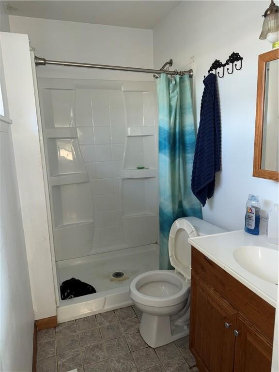 bathroom featuring a shower with shower curtain, vanity, and toilet