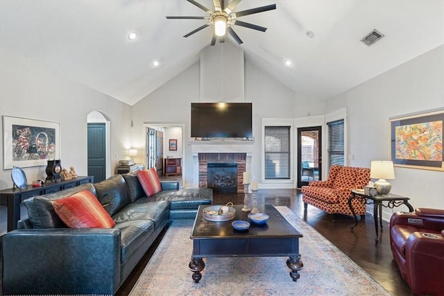 living room with a fireplace, high vaulted ceiling, ceiling fan, and dark hardwood / wood-style floors