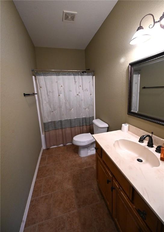 bathroom featuring toilet, curtained shower, and vanity