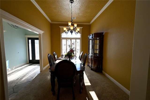 dining area featuring a textured ceiling, an inviting chandelier, crown molding, and carpet floors