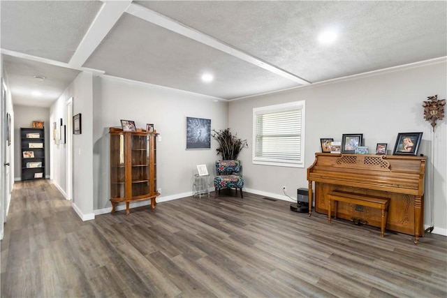 sitting room featuring a textured ceiling, baseboards, wood finished floors, and ornamental molding