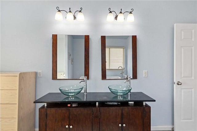 full bathroom with double vanity and a sink