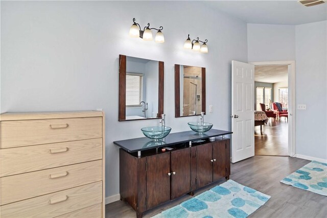 13693 N Mount Pleasant Rd, Gravette, AR 72736 - full bathroom featuring wood finished floors, a shower stall, connected bathroom, double vanity, and baseboards