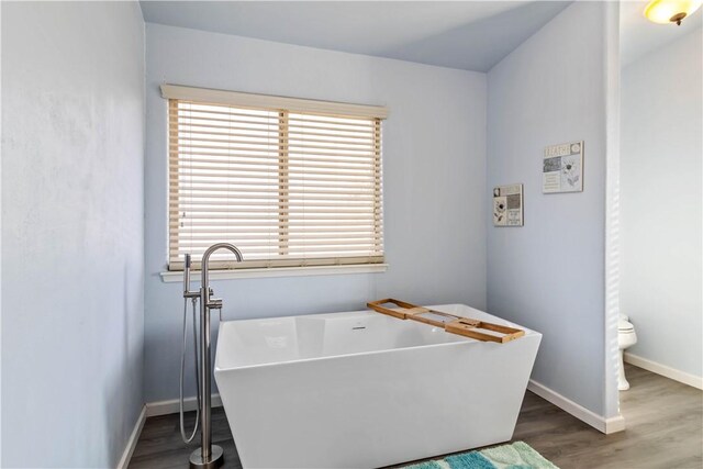 clothes washing area with hardwood / wood-style flooring