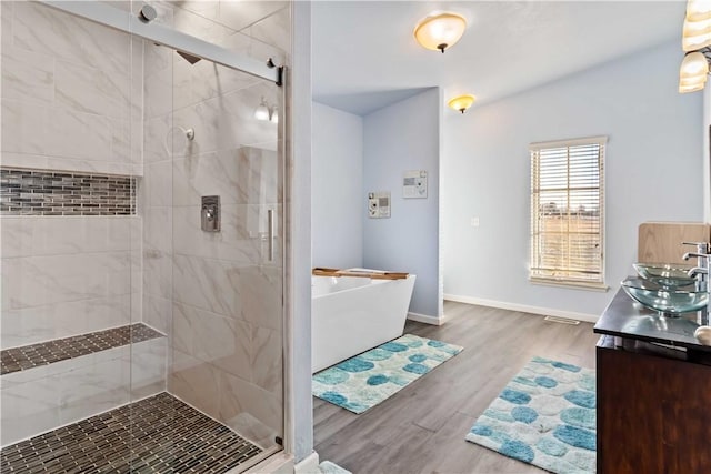 13693 N Mount Pleasant Rd, Gravette, AR 72736 - full bathroom with a shower stall, a freestanding bath, wood finished floors, and vanity