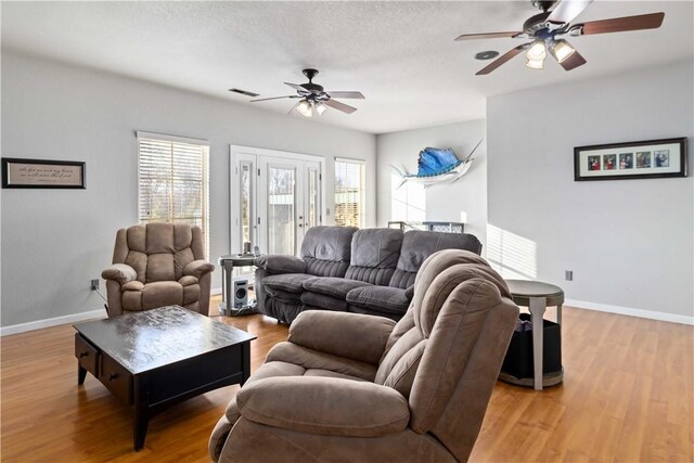 living room featuring ceiling fan and hardwood / wood-style flooring