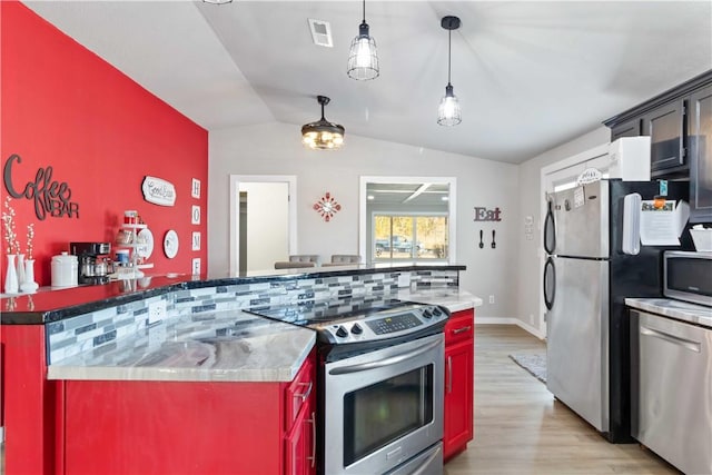 kitchen with light wood finished floors, lofted ceiling, visible vents, hanging light fixtures, and appliances with stainless steel finishes