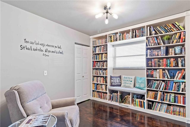 living area with bookshelves and wood finished floors