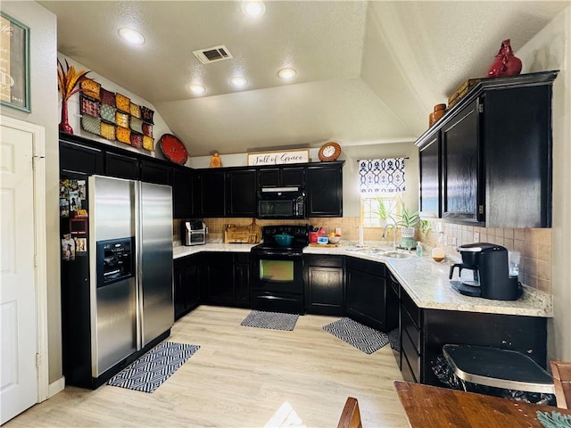 kitchen featuring visible vents, a sink, black appliances, light countertops, and dark cabinets