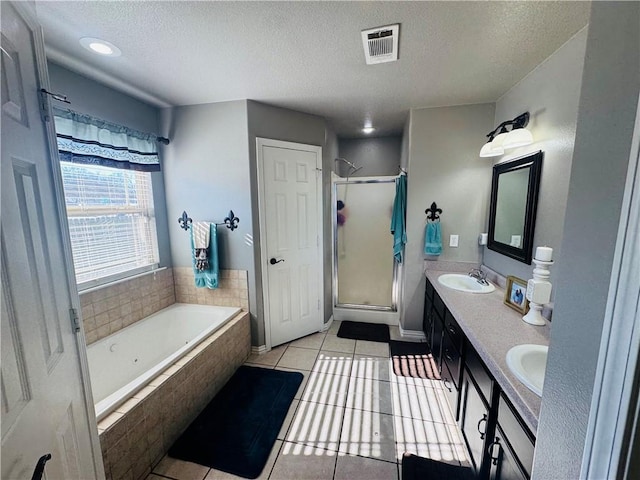 full bathroom featuring tile patterned floors, visible vents, a stall shower, a textured ceiling, and a bath