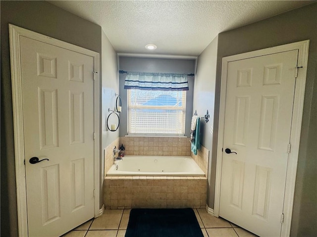 full bathroom with tile patterned floors, a jetted tub, and a textured ceiling