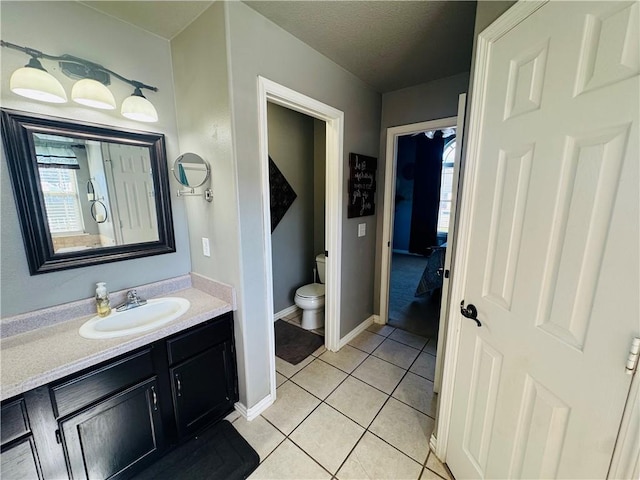 bathroom featuring vanity, tile patterned floors, toilet, and a healthy amount of sunlight