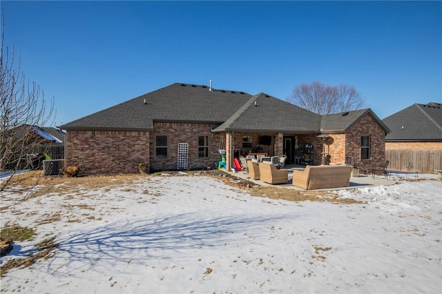 snow covered back of property featuring central AC and outdoor lounge area