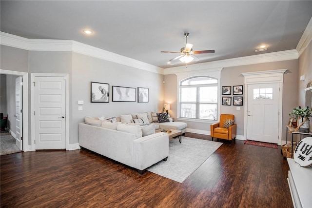 living room featuring dark wood-type flooring, ceiling fan, and crown molding