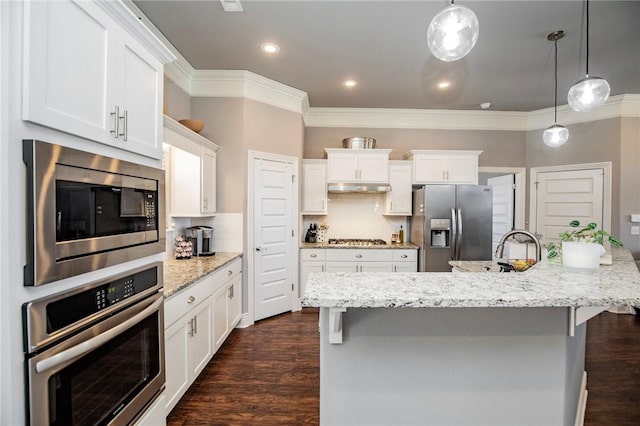 kitchen featuring stainless steel appliances, white cabinetry, tasteful backsplash, and hanging light fixtures