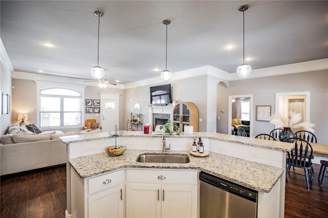 kitchen featuring stainless steel dishwasher, white cabinetry, sink, and hanging light fixtures