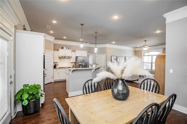 dining space with ceiling fan, crown molding, and dark wood-type flooring