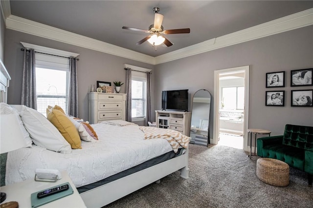 carpeted bedroom featuring ceiling fan, ornamental molding, and ensuite bath