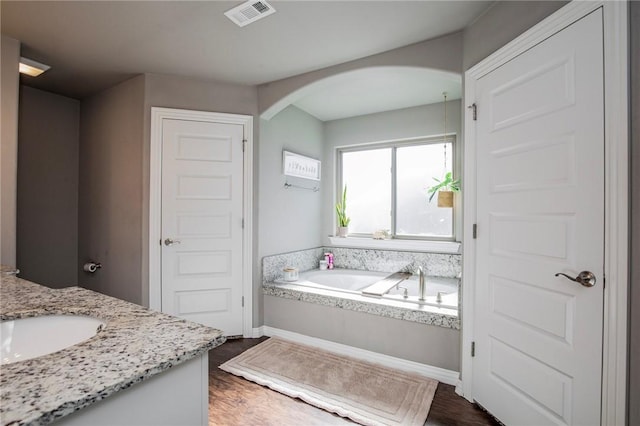 bathroom with vanity, hardwood / wood-style flooring, and a bathing tub