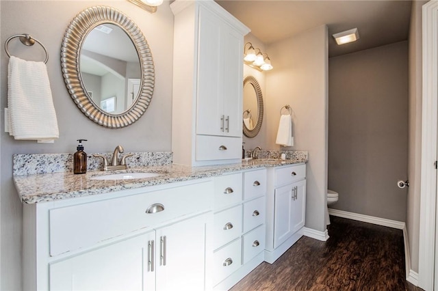 bathroom featuring toilet, vanity, and hardwood / wood-style floors