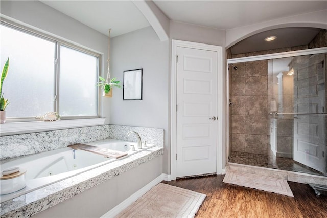 bathroom featuring wood-type flooring and separate shower and tub