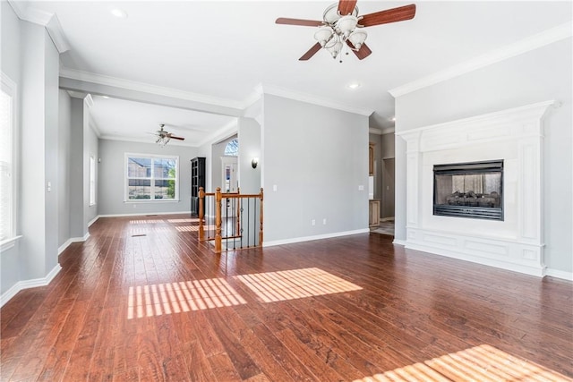 unfurnished living room featuring ornamental molding, dark wood-type flooring, and ceiling fan