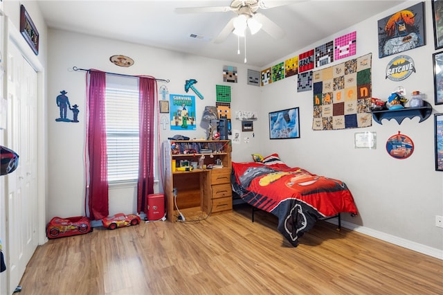 bedroom featuring wood-type flooring, multiple windows, and ceiling fan