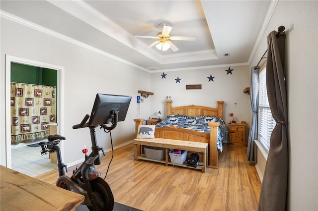 bedroom with hardwood / wood-style flooring, ceiling fan, a tray ceiling, and crown molding