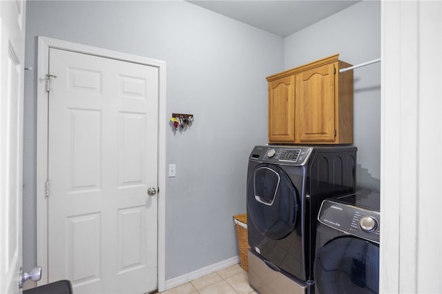 laundry room with washer and dryer, cabinets, and light tile patterned flooring