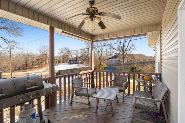 wooden deck with ceiling fan and area for grilling