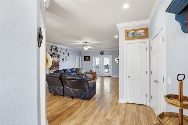 living room with ceiling fan, light hardwood / wood-style floors, and ornamental molding