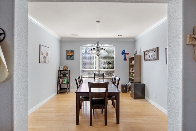 dining area with a notable chandelier, crown molding, and light hardwood / wood-style flooring