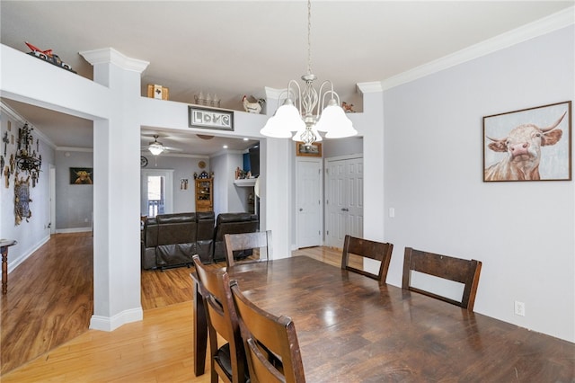 dining area with ceiling fan with notable chandelier, wood-type flooring, and ornamental molding