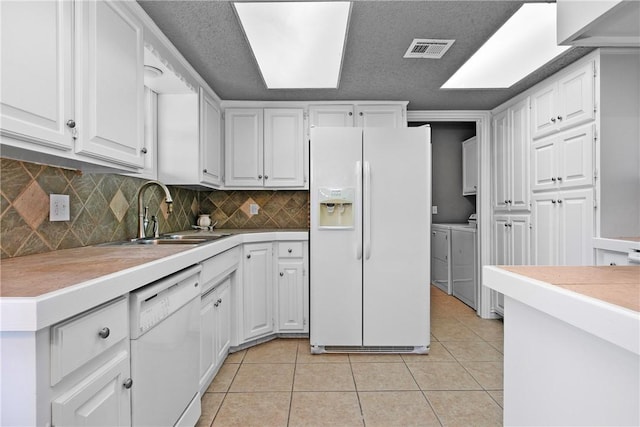 kitchen with white cabinetry, light tile patterned floors, white appliances, and sink